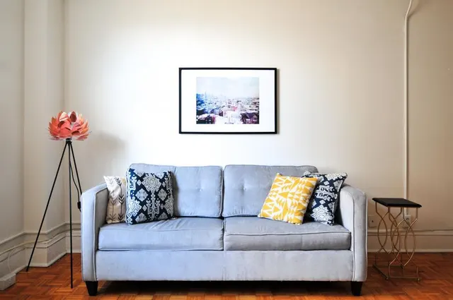 Photo with studio couch, table, pillow and picture frame