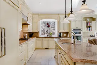 Photo with cabinetry, faucet, kitchen appliance and lamp