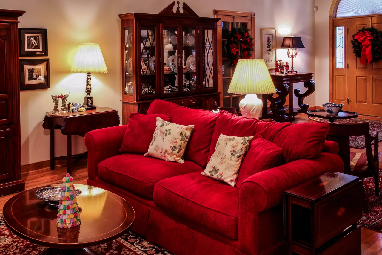 Photo with studio couch, desk, cabinetry, coffee table, picture frame and pillow