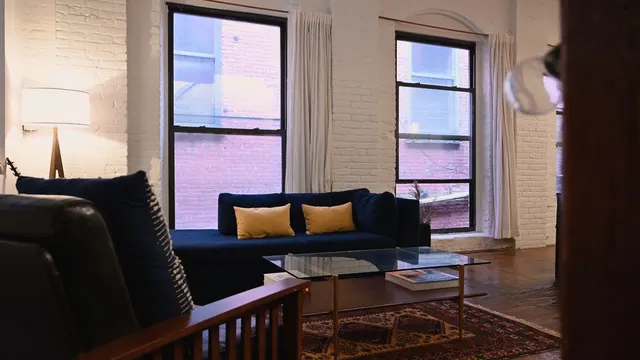 Video with curtains, lamp, pillow, sofa, coffee table and rug