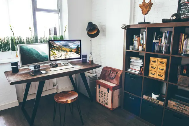 Photo with handbag, desk, cabinetry, television, trash bin/can and lamp