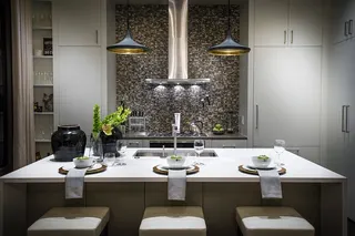 Photo with kitchen & dining room table, cabinetry, houseplant, lamp and vase