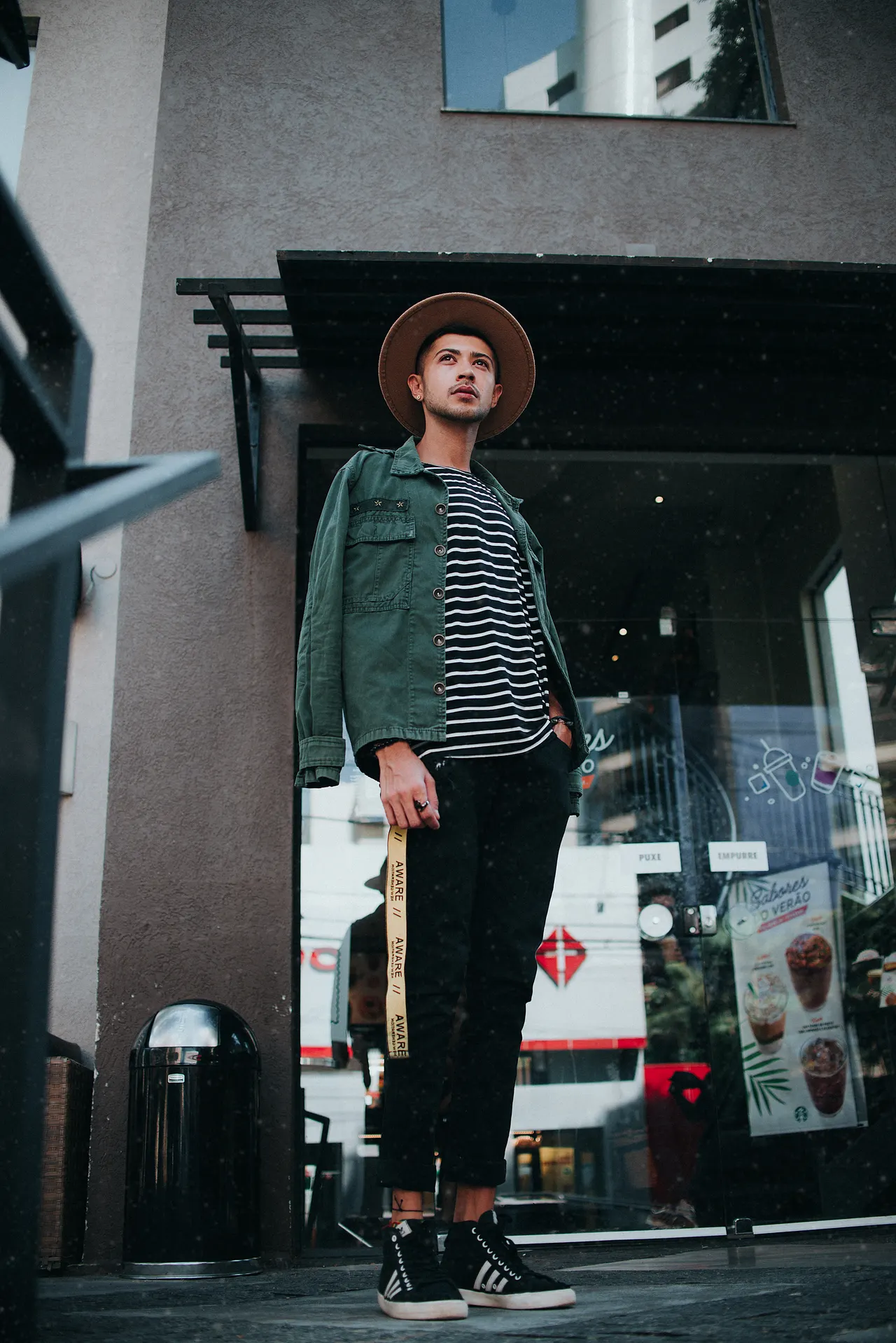 Photo with trousers, jacket, hat, sneakers and trash bin/can