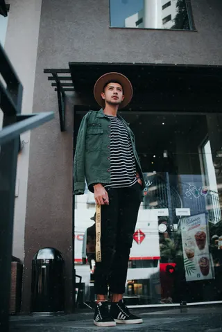 Photo with trousers, jacket, hat, sneakers and trash bin/can