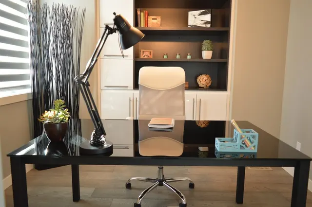 Photo with cabinetry, chair, desk, houseplant and lamp
