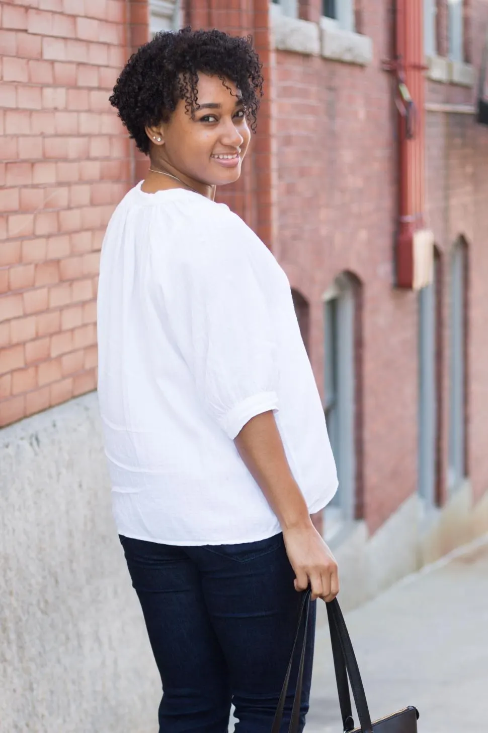 Photo with trousers, white shirt, handbag and necklace