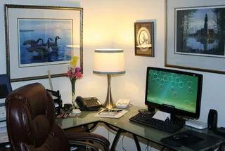 Photo with desk, television, lamp, picture frame and computer keyboard