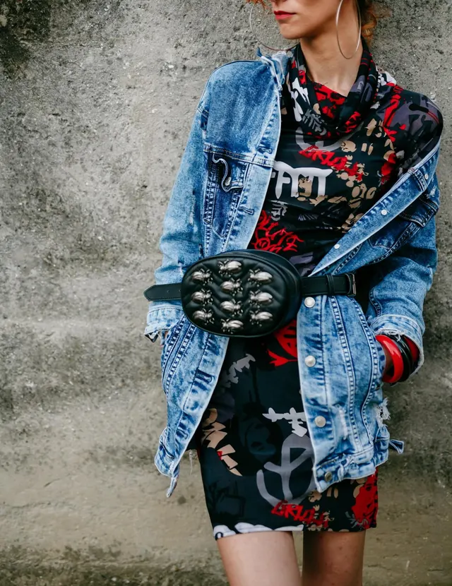 Photo with jean jacket, red short skirt, black belt and large hoop earrings