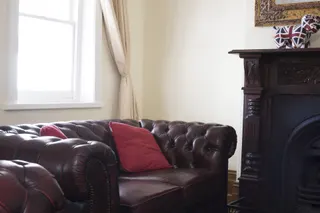 Photo with cabinetry, studio couch, window, pillow and curtain